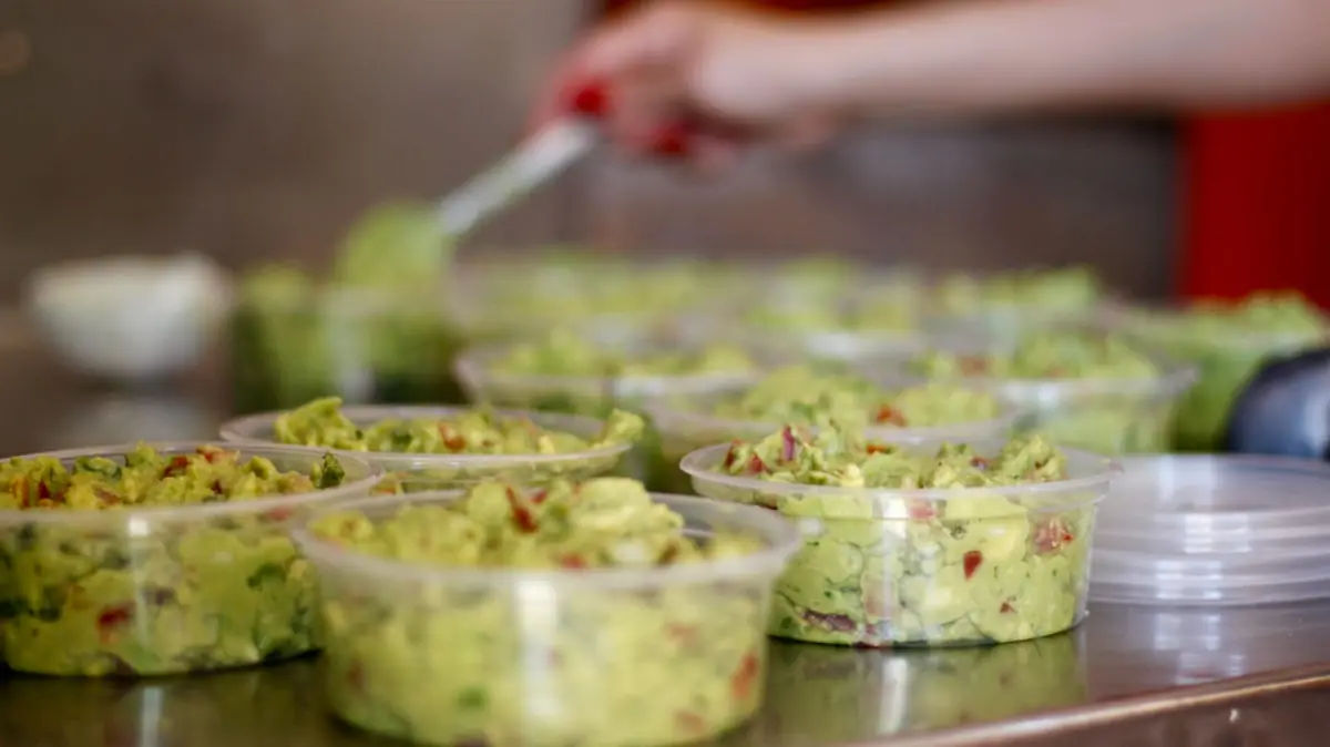 Vasitos de guacamole en una mesa de acero